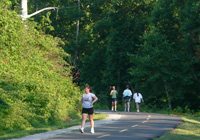 Photo of runners on paved trail with tall electric transmission towers