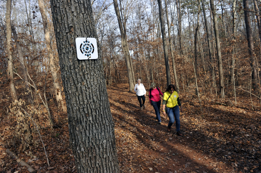 Photo of people walking along trail in woods